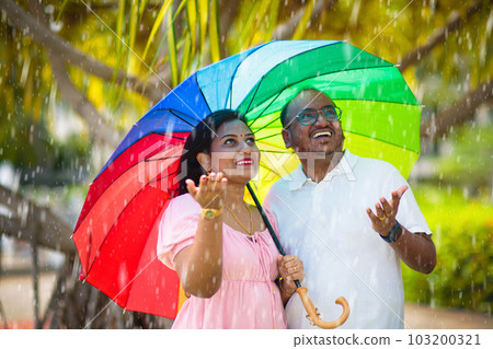 Young Indian couple in love in rain Young Indian couple in love in rain 103200321