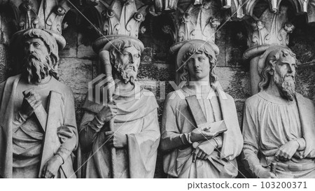 Sculptural images of the Holy Apostles on the wall of the facade of Saint Fin Barre's Cathedral in Cork, Ireland. The Apostles Andrew, James major, Thomas, Matthias. Monochrome. 103200371