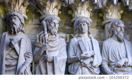 Sculptural images of the Holy Apostles on the wall of Saint Fin Barre's Cathedral in Cork, Ireland. The Apostles Andrew, James major, Thomas, Matthias. Black and white image. Monochrome. 103200372