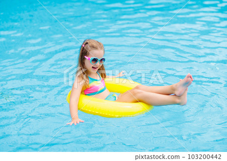 Child in swimming pool on toy ring. Kids swim. 103200442