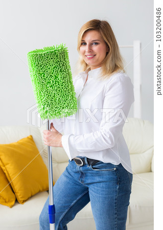 Portrait of housewife woman holds mop pad - cleaning concept Portrait of housewife woman holds mop pad - cleaning concept 103200486