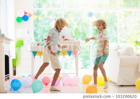 Kids birthday party. Child opening present. Kids birthday party. Child opening present. 103200620