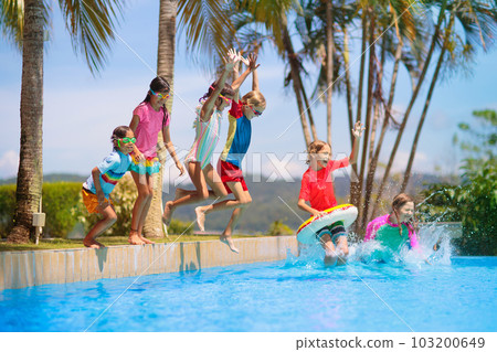 Kids jump into swimming pool. Summer water fun. 103200649
