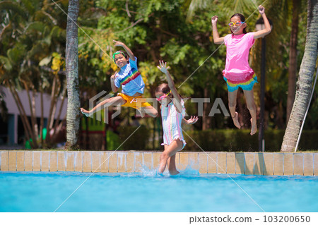 Kids jump into swimming pool. Summer water fun. Kids jump into swimming pool. Summer water fun. 103200650