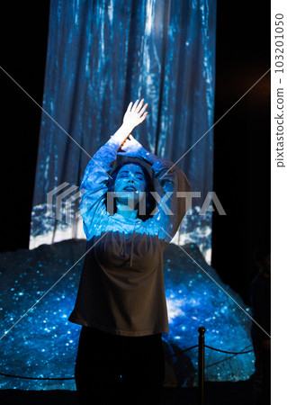 Schizophrenia and enlightenment. Portrait of young woman with closed eyes posing in blue light from illusion of waterfall. Vertical orientation. Concept of psychology, mental health and dreaming Schizophrenia and enlightenment. Portrait of young woman with closed eyes posing in blue light from illusion of waterfall. Vertical orientation. Concept of psychology, mental health and dreaming 103201050