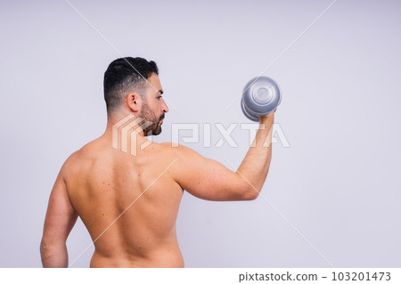 Athletic man doing exercises with dumbbell at biceps on white background. Strength and motivation Athletic man doing exercises with dumbbell at biceps on white background. Strength and motivation 103201473