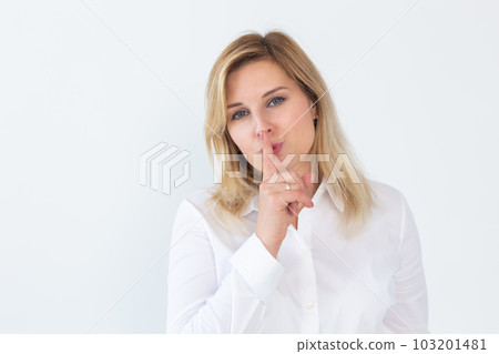 Beautiful young Caucasian woman isolated on white studio background hold finger at lips ask be silent quiet. Millennial female look at camera tell share mystery, announce secret sale or discount Beautiful young Caucasian woman isolated on white studio background hold finger at lips ask be silent quiet. Millennial female look at camera tell share mystery, announce secret sale or discount 103201481