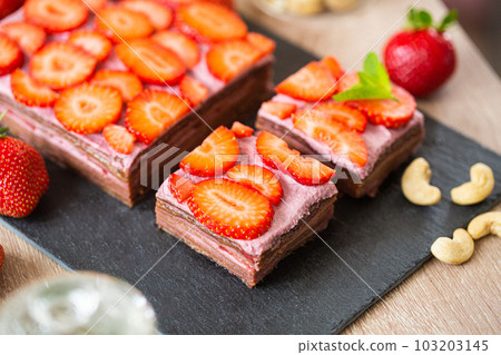 No baked raw cake made with dates, cashews and strawberries, close up 103203145