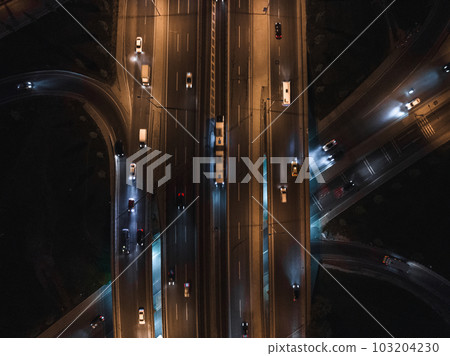Top view of car traffic transport on crossing multiple lanes highway or expressway in Asia city at night. Civil engineering, technology background, Asian transportation concept Top view of car traffic transport on crossing multiple lanes highway or expressway in Asia city at night. Civil engineering, technology background, Asian transportation concept 103204230