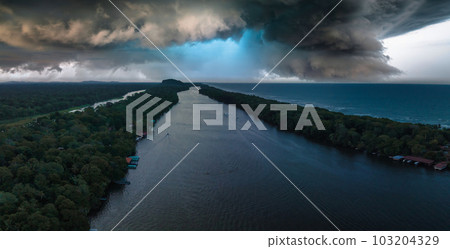 Village of Tortuguero. Caribbean sea on the one side, village inside the jungle in the middle, and huge river on the otjer side. Amazing place full of wildlife in Costa Rica at dusk. 103204329
