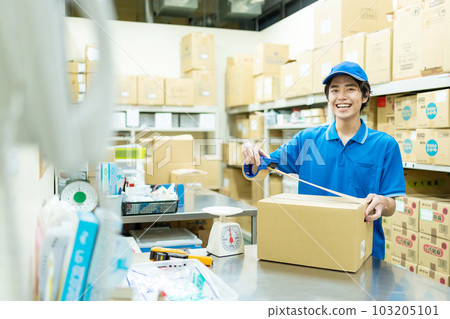 Young man packing in warehouse Young man packing in warehouse 103205101