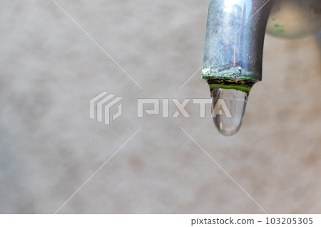 Water about to drip from the tip of an old water pipe Water about to drip from the tip of an old water pipe 103205305