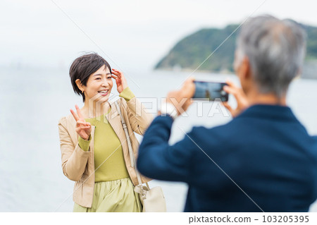 一對中年夫婦用智能手機拍紀念照 103205395
