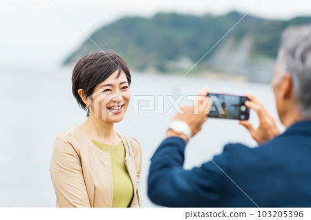 A middle-aged couple taking a commemorative photo with a smartphone A middle-aged couple taking a commemorative photo with a smartphone 103205396