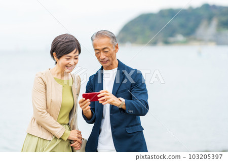 Senior couple snuggling at the sea Senior couple snuggling at the sea 103205397