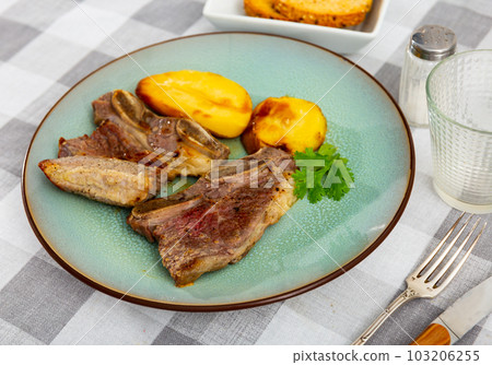 Grilled beef spare ribs with baked potatoes and greens Grilled beef spare ribs with baked potatoes and greens 103206255