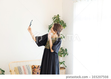 Photo of a woman taking a picture with a smartphone 103207508