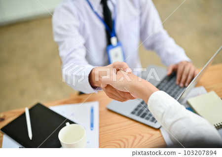 Close-up image of a businessman shaking hands with his business client in the office. 103207894