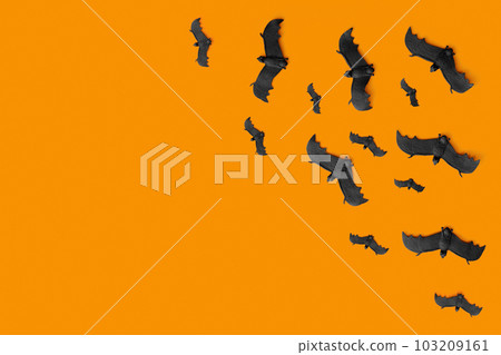A lot of black bats flying on an orange background 103209161