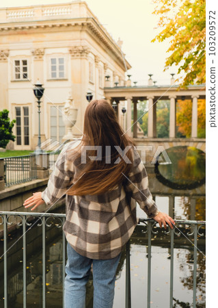 Tourist attraction woman travel enjoying nature sightseeing Baths classicist Palace on the Isle in Lazienki Park touristic place in Warsaw. Lazienki Royal Baths Park, Baroque columns Warsaw Poland Tourist attraction woman travel enjoying nature sightseeing Baths classicist Palace on the Isle in Lazienki Park touristic place in Warsaw. Lazienki Royal Baths Park, Baroque columns Warsaw Poland 103209572