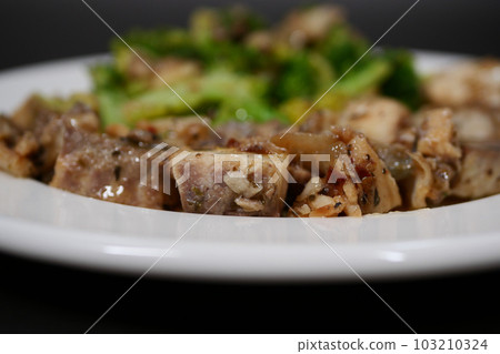 sauteed mushrooms with garlic and parsley on a black plate on white background  103210324