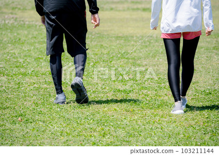 Feet of a young couple exercising in the park 103211144