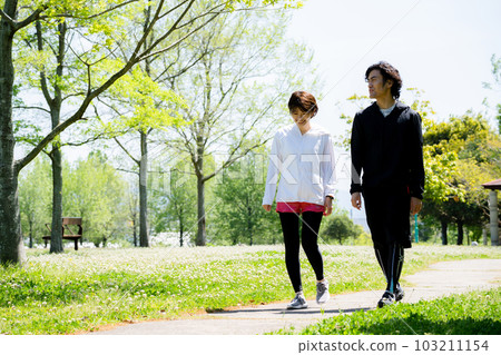 young couple walking in the park 103211154