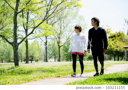 young couple walking in the park 103211155