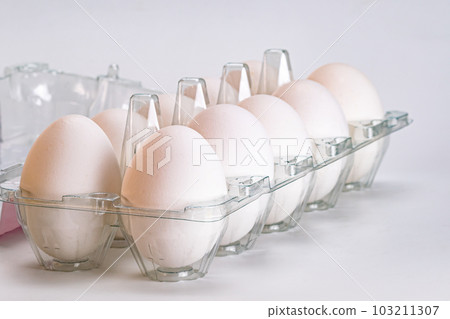 Group of organic white eggs in transparent plastic carton. Group of organic white eggs in transparent plastic carton. 103211307