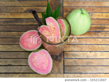 Pink guava ice tea on wooden planks background Pink guava ice tea on wooden planks background 103211607