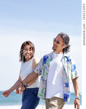 中老年夫婦手牽手走在沙灘上 103211853