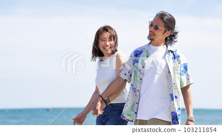 中老年夫婦手牽手走在沙灘上 103211854