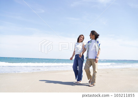 中老年夫婦手牽手走在沙灘上 103211855