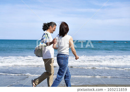 微笑著走在沙灘上的中年男女 103211859