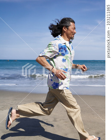 Middle senior man running on the beach under the blue sky 103211865