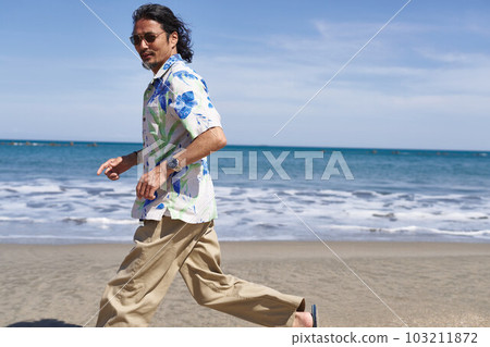 Middle senior man running on the beach under the blue sky 103211872