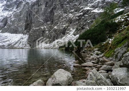 Czarny Staw pod Rysamy or Black Pond lake near the Morskie Oko Snowy Mountain Hut in Polish Tatry mountains, drone view, Zakopane, Poland. 4k Aerial view shot of beautiful green hills and mountains in 103211997