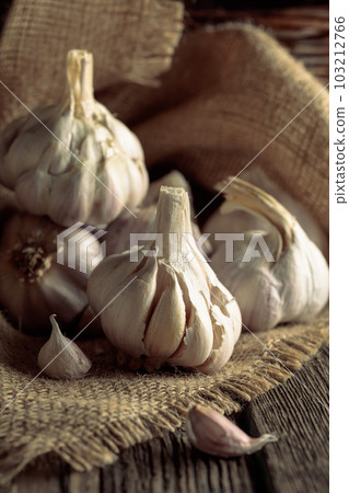 Garlic on an old wooden table. 103212766