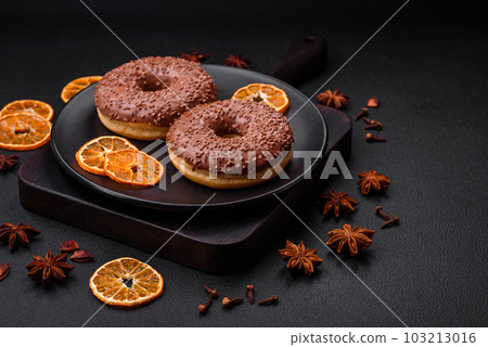 Delicious chocolate glazed donut sprinkled with chocolate chips Delicious chocolate glazed donut sprinkled with chocolate chips 103213016