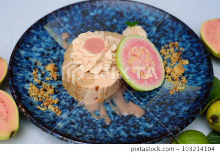 Guava Roll Cake on blue plate on light background with ripe guava fruit 103214104