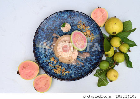 Guava Roll Cake on blue plate on light background with ripe guava fruit Guava Roll Cake on blue plate on light background with ripe guava fruit 103214105