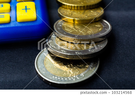 Money concept. Blue calculator with coins euro, close up, dark background 103214568