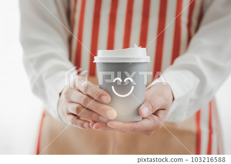 closeup woman wearing apron holding paper cup of hot coffee 103216588