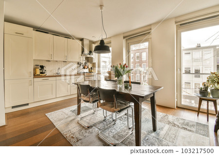 a kitchen, dining room and living area in an apartment with hardwood flooring on the other side of the room 103217500