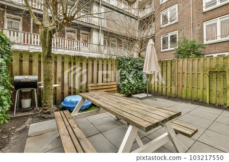 a backyard area with a picnic table and grill in the back yard, surrounded by plants and trees on either side a backyard area with a picnic table and grill in the back yard, surrounded by plants and trees on either side 103217550