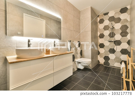 a bathroom with black and white hexagon tiles on the walls, wood counters and toilet in the corner 103217778
