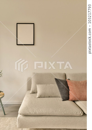 a living room with a couch, coffee table and plant in the corner on the left side of the room a living room with a couch, coffee table and plant in the corner on the left side of the room 103217793