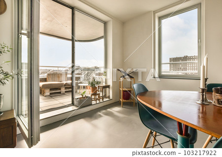 a dining table and chairs in a room with large windows that look out onto the cityscaped view 103217922