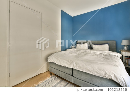 a bedroom with blue walls and white furniture in the corner, including a bed that's made to look like a headboard 103218236