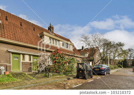a street with cars parked on the side and houses in the background, taken from an angle to the ground 103218372